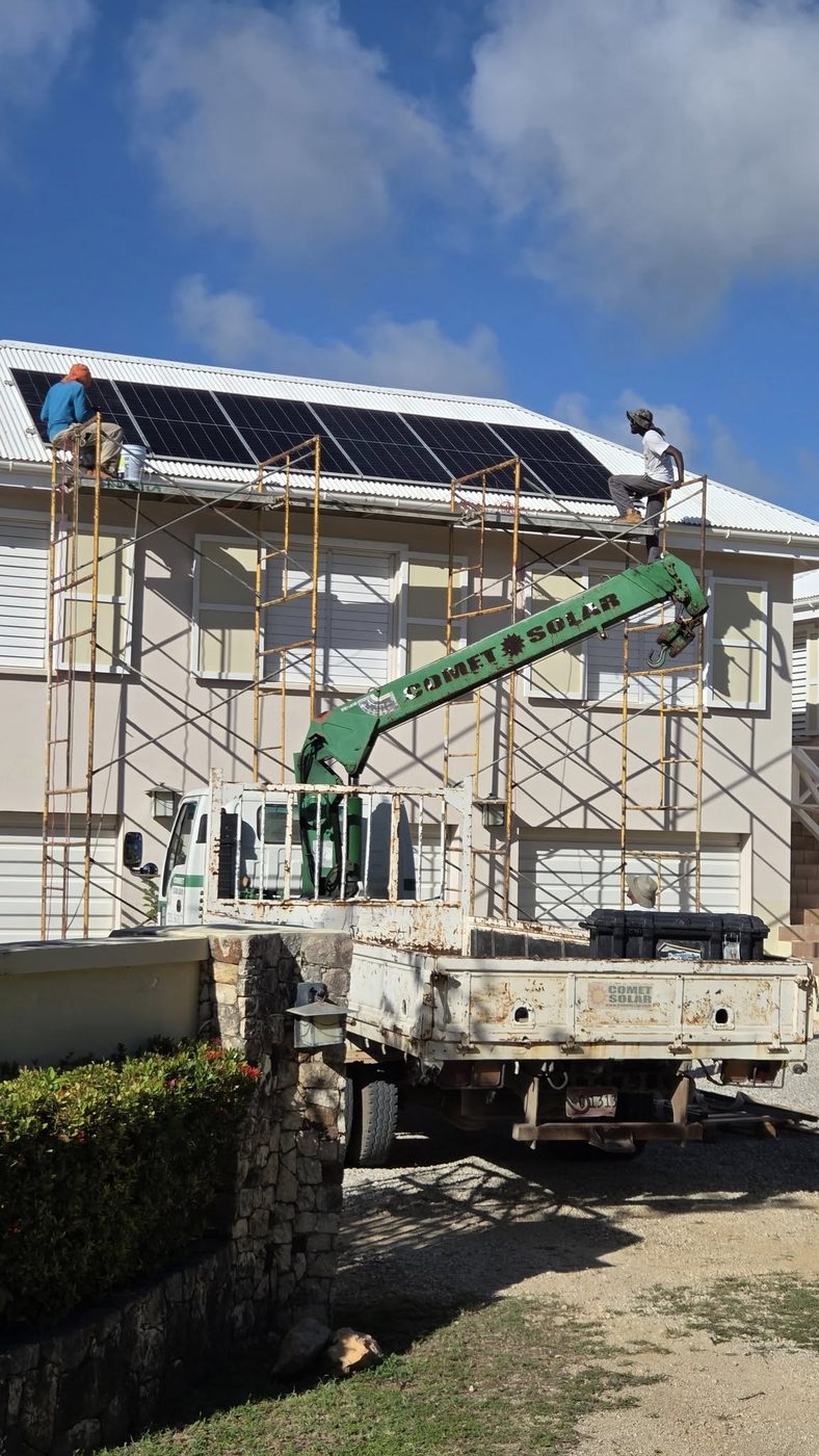 Comet Solar crane truck and crew installing solar panels on commercial building